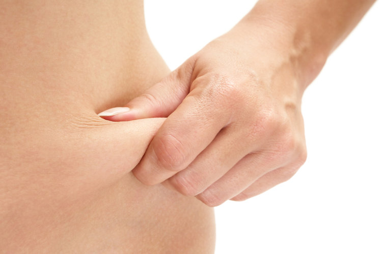 Woman pinching her paunch. Isolated on a white background, showing problem area for CoolSculpting