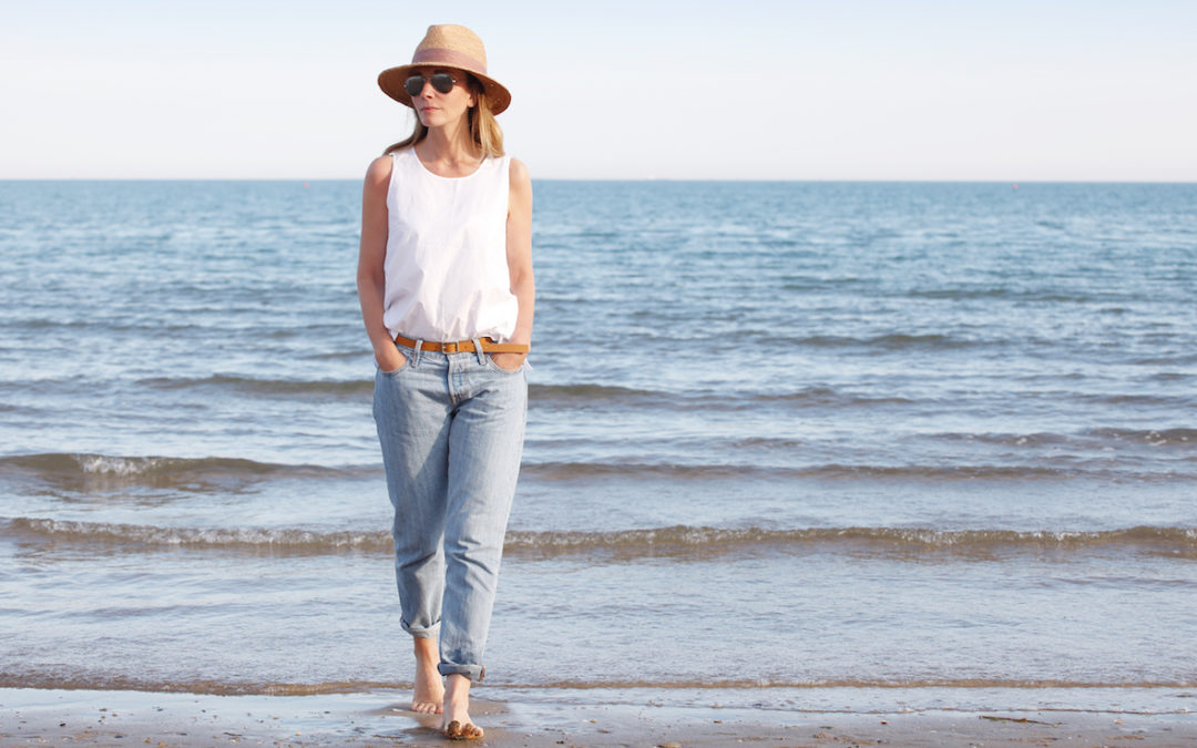 A middle aged women walking confidently on the beach after having CoolSculpting treatment