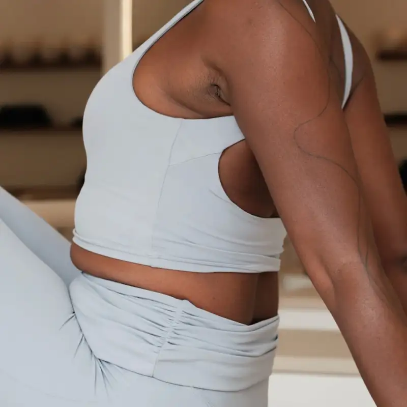 A woman in white leggings and white shirt exercising